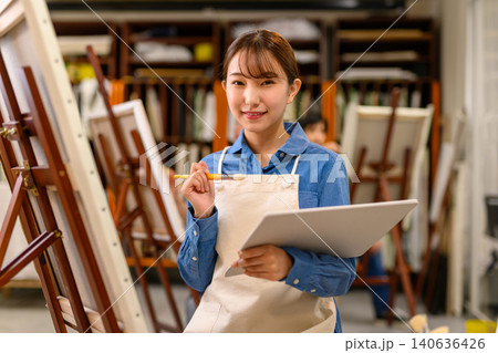 絵筆を持って微笑む若い女性美術学生 絵筆を持って微笑む若い女性美術学生 140636426