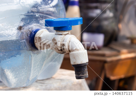 Close Up of Plastic Water Container Faucet with Blue Valve Handle for Clean Water Distribution Close Up of Plastic Water Container Faucet with Blue Valve Handle for Clean Water Distribution 140637115
