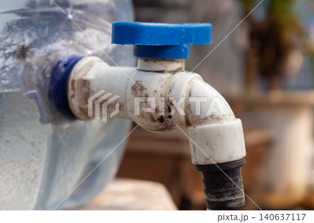 Close Up of Plastic Water Container Faucet with Blue Valve Handle for Clean Water Distribution Close Up of Plastic Water Container Faucet with Blue Valve Handle for Clean Water Distribution 140637117