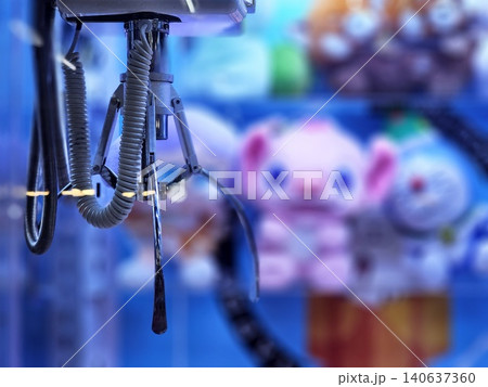 Close up of a Mechanical Gripper Arm inside an Arcade Claw Machine, Symbol of Fun, Entertainment and Chance in Amusement Arcades. 140637360