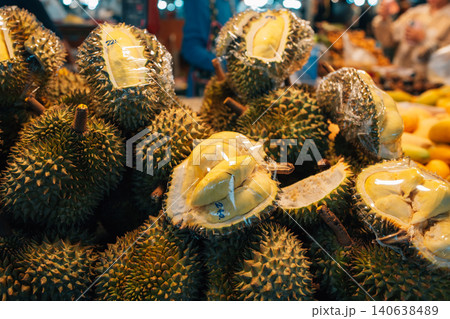 Fresh whole and cut durians wrapped in plastic for sale at a local market in Thailand Fresh whole and cut durians wrapped in plastic for sale at a local market in Thailand 140638489