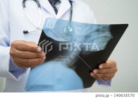 Doctor examining cervical vertebrae bone radiography xray film. Doctor examining cervical vertebrae bone radiography xray film. 140638570