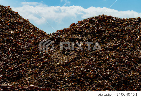 Pile of brown bottle for recycle in recycling factory. Glass waste for recycle. Dump of brown beer and wine glass bottle. Smashed glass bottle garbage. Recycling business. Sustainable glass packaging. 140640451