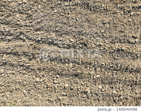 Drone view of plowed agricultural field after soil preparation with tractor. Aerial farmland texture. Cultivation pattern and rural land management for crop planting and sustainable agriculture. Drone view of plowed agricultural field after soil preparation with tractor. Aerial farmland texture. Cultivation pattern and rural land management for crop planting and sustainable agriculture. 140640496