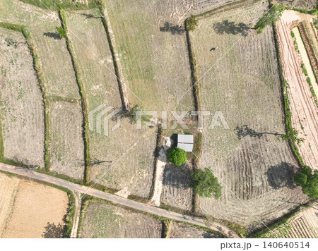 Aerial view of harvested farmland with rural field patterns. Agricultural land use, seasonal crop production and sustainable countryside development. traditional farming practice. Climate adaptation. Aerial view of harvested farmland with rural field patterns. Agricultural land use, seasonal crop production and sustainable countryside development. traditional farming practice. Climate adaptation. 140640514