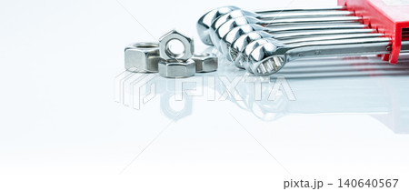 Metal hexagon nuts and chrome wrenches isolated on white background. Mechanic tools for maintenance. Hardware tool. Fastener with a threaded hole. Set chrome spanner wrench and nuts. Silver wrenches. Metal hexagon nuts and chrome wrenches isolated on white background. Mechanic tools for maintenance. Hardware tool. Fastener with a threaded hole. Set chrome spanner wrench and nuts. Silver wrenches. 140640567