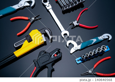 Mechanic tools on black background. Set of pipe wrench, bent wrench, nuts, spanner, pliers, and chrome combination wrenches. Service technician tools for maintenance and fix work. Hardware workshop. Mechanic tools on black background. Set of pipe wrench, bent wrench, nuts, spanner, pliers, and chrome combination wrenches. Service technician tools for maintenance and fix work. Hardware workshop. 140640568