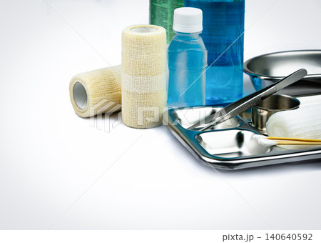 Wound care dressing set and stainless steel plate, forceps, alcohol bottle, cohesive elastic bandage, cotton sticks, container for surgical. Medical supply. Medical equipment tools on white background 140640592