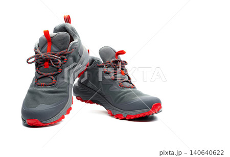 Men trekking shoes isolated on white background. Gray-red hiking shoes. Safety footwear for climbing. Adventure gear. Lightweight rubber trekking shoes with safety sole. Modern and breathable design. Men trekking shoes isolated on white background. Gray-red hiking shoes. Safety footwear for climbing. Adventure gear. Lightweight rubber trekking shoes with safety sole. Modern and breathable design. 140640622
