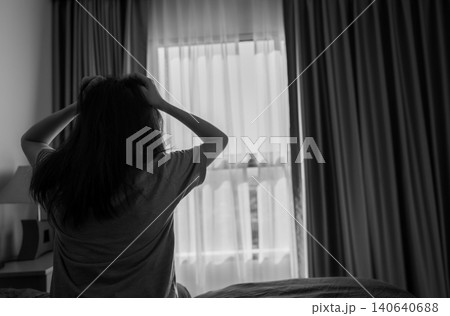 A stressed young woman holding her head and pulling her hair in a dark room. Anxiety, depression, emotional distress, mental health struggles and feelings of hopelessness. Psychological pressure. A stressed young woman holding her head and pulling her hair in a dark room. Anxiety, depression, emotional distress, mental health struggles and feelings of hopelessness. Psychological pressure. 140640688