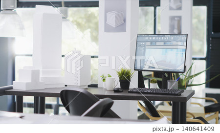 Designing office has empty desk with computer operating CAD, production layouts and blueprints on the design table, architectural work environment fitted with latest modeling appliances. 140641409