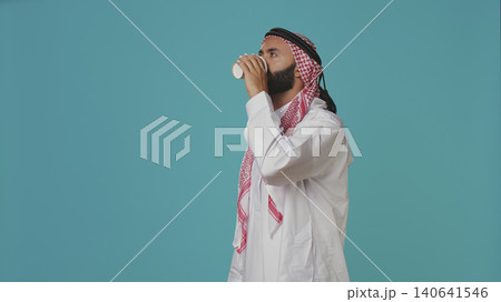 Muslim adult serving coffee cup in the morning, enjoying refreshment drink with caffeine and energy. Muslim adult serving coffee cup in the morning, enjoying refreshment drink with caffeine and energy. 140641546