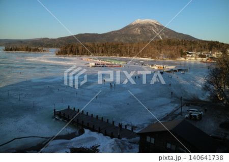 結氷した阿寒湖の湖上と阿寒岳の夕暮れの空撮 結氷した阿寒湖の湖上と阿寒岳の夕暮れの空撮 140641738
