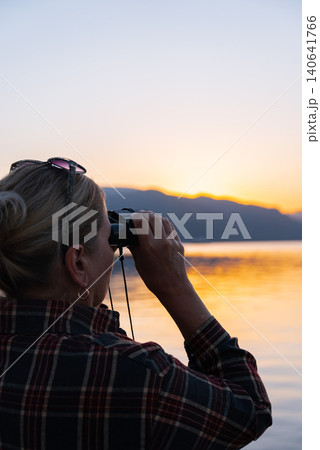 Woman Looking Through Binoculars on Marmaris Waterfront at Golden Hour Woman Looking Through Binoculars on Marmaris Waterfront at Golden Hour 140641766