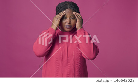 Woman in sweater having headache with fashionable woman wearing pink sweater suffering a bad headache. Woman in sweater having headache with fashionable woman wearing pink sweater suffering a bad headache. 140642028