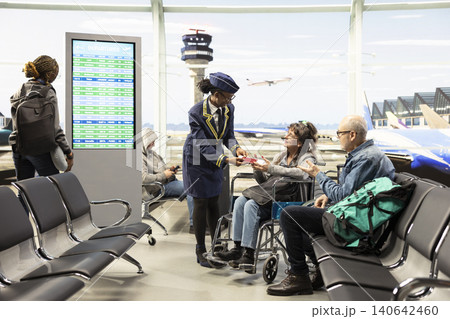 Caring airline staff helping elderly passengers with mobility aid at airport terminal, giving directions and boarding information. Senior couple representing inclusion and modern travel lifestyle. Caring airline staff helping elderly passengers with mobility aid at airport terminal, giving directions and boarding information. Senior couple representing inclusion and modern travel lifestyle. 140642460