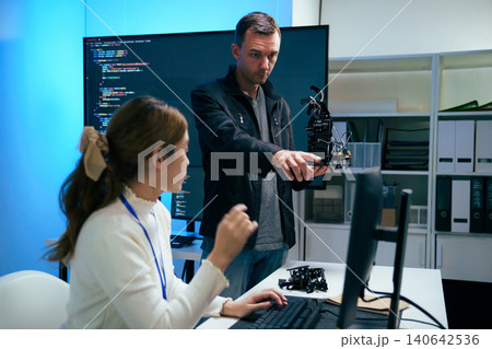 Diverse team of software engineers collaborating on code at office 140642536