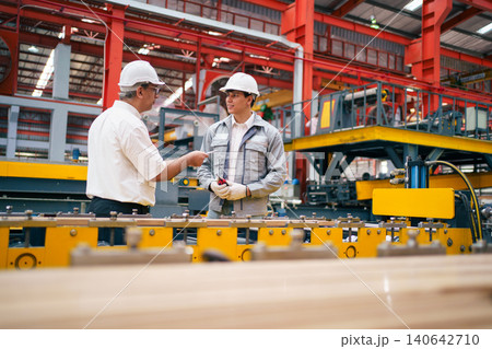 Senior manager and engineer discussing work in factory 140642710
