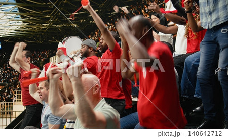 Passionate soccer fans erupting in celebration after winner goal during the final whistle of intense football match. Happy supporters cheering with raised fists, pure joy and excitement. Passionate soccer fans erupting in celebration after winner goal during the final whistle of intense football match. Happy supporters cheering with raised fists, pure joy and excitement. 140642712