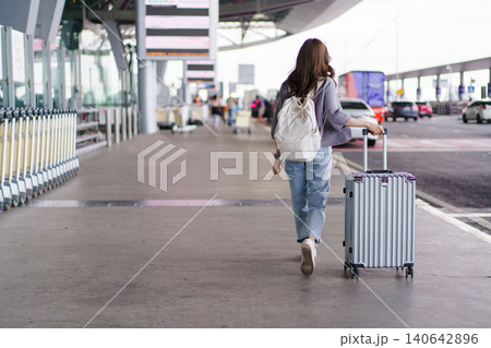 Asian woman traveler walking with suitcase at airport terminal 140642896