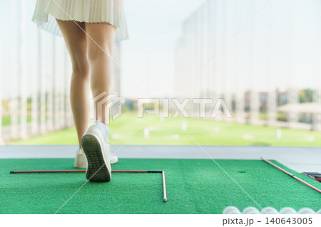 Back view of woman golfer lower body after swing at driving range. Back view of woman golfer lower body after swing at driving range. 140643005