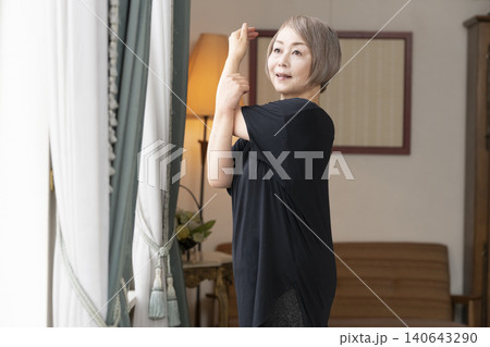 リビングでストレッチをするシニア女性 140643290
