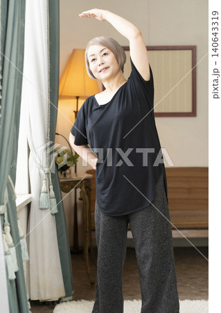 リビングでストレッチをするシニア女性 リビングでストレッチをするシニア女性 140643319