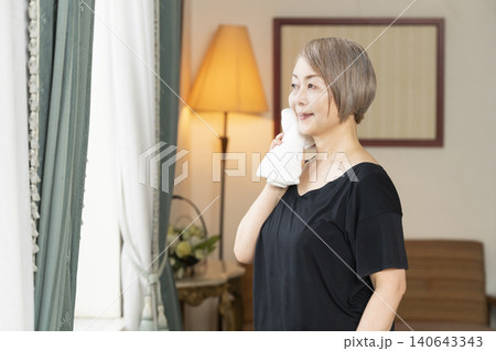 リビングでストレッチをするシニア女性 リビングでストレッチをするシニア女性 140643343