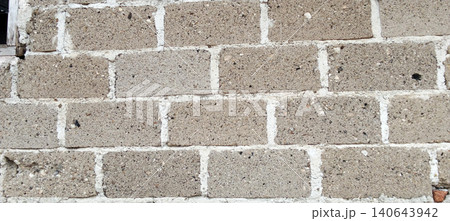 An old concrete brick wall showing rough texture, visible mortar lines, and fine weathering details. 140643942