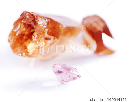 Gemstone, citrine and pink diamond in studio with isolated white background for natural resource, jewel and sparkle for luxury. Rock, crystal and reflection in closeup for shine, glow and mineral 140644151