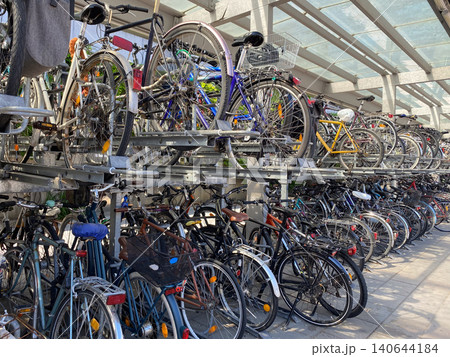 Modern double decker bicycle parking rack full of city bikes at a station. 140644184