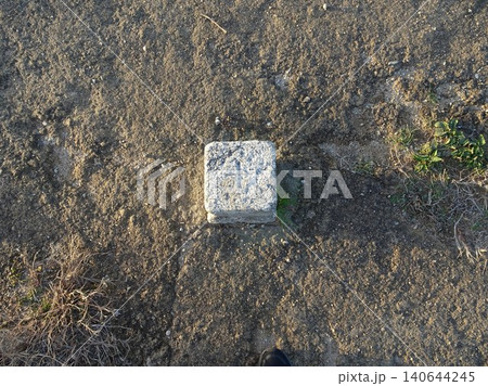 鳥取県米子城跡の山頂天守台に設置された「一等三角点」の標石と上面の刻み(真上からの俯瞰クローズアップ 鳥取県米子城跡の山頂天守台に設置された「一等三角点」の標石と上面の刻み(真上からの俯瞰クローズアップ 140644245
