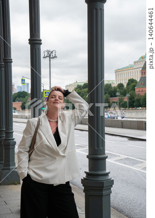Woman stands between columns on Sofiyskaya Embankment, Moscow, waterfront roadway, urban architecture, contemporary metropolitan portrait, confident presence. Professional profile, female leadership Woman stands between columns on Sofiyskaya Embankment, Moscow, waterfront roadway, urban architecture, contemporary metropolitan portrait, confident presence. Professional profile, female leadership 140644461