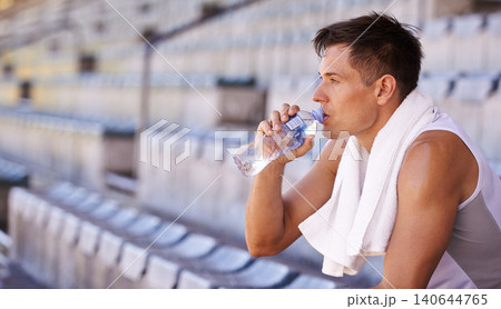 Stadium, relax man or athlete for drinking water and commitment to fitness for sprinting competition. Person, competitive and runner with thinking in sport, planning and health drink for performance Stadium, relax man or athlete for drinking water and commitment to fitness for sprinting competition. Person, competitive and runner with thinking in sport, planning and health drink for performance 140644765
