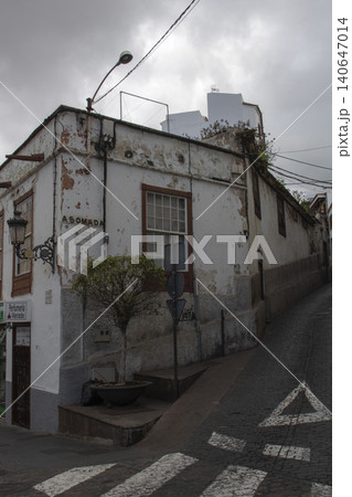 Old peeling building on urban cobblestone street corner Old peeling building on urban cobblestone street corner 140647014