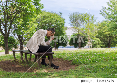 公園のベンチに座って落ち込む中高年日本人男性 公園のベンチに座って落ち込む中高年日本人男性 140647319