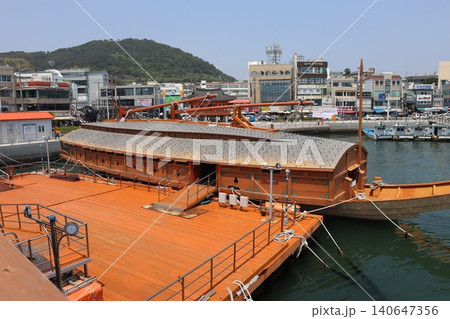 Traditional Wooden Boat at Harbor with Urban Background Traditional Wooden Boat at Harbor with Urban Background 140647356