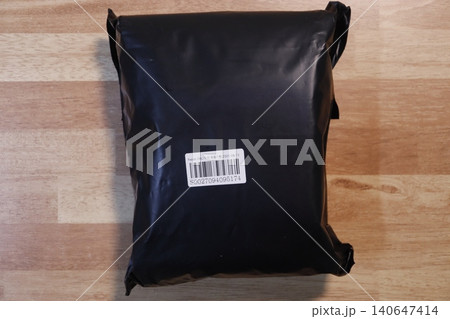 Black Plastic Bag with Barcode on Wooden Surface Black Plastic Bag with Barcode on Wooden Surface 140647414