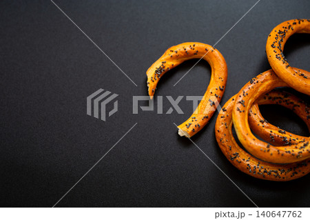 Crunchy bakery rings with poppy seeds on black backdrop Crunchy bakery rings with poppy seeds on black backdrop 140647762