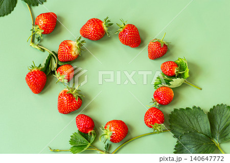 Organic garden strawberries arranged on pastel green backdrop Organic garden strawberries arranged on pastel green backdrop 140647772