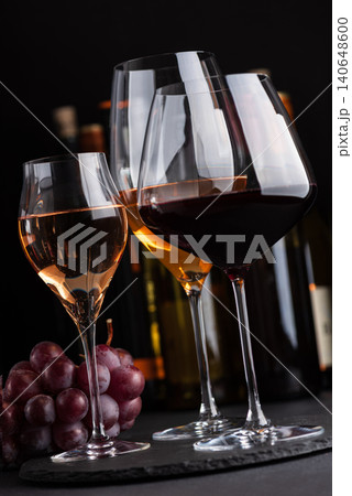 White, rose, and red wine glasses standing on dark surface White, rose, and red wine glasses standing on dark surface 140648600