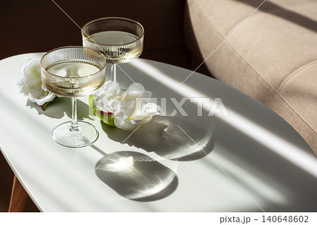 Two coupe glasses with sparkling wine and white flowers 140648602