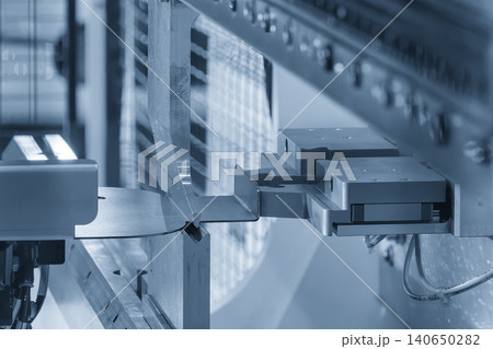 Industrial robotic arm operating a precision sheet metal bending process with an automatic system. Industrial robotic arm operating a precision sheet metal bending process with an automatic system. 140650282