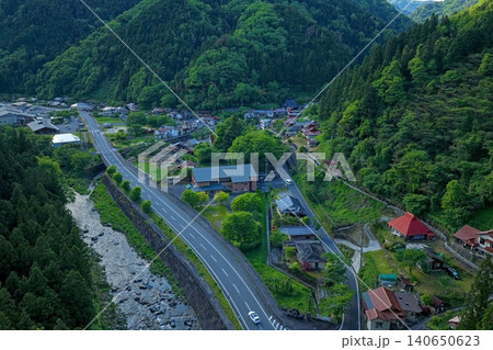 広島県湯来温泉街を新緑の山並みとともに俯瞰した空撮写真 広島県湯来温泉街を新緑の山並みとともに俯瞰した空撮写真 140650623