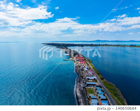 Island with boats. Coastal land with vibrant rooftops. Serene shore featuring colorful houses and boats. Tranquil seaside area with lively fishing and tourist boats Island with boats. Coastal land with vibrant rooftops. Serene shore featuring colorful houses and boats. Tranquil seaside area with lively fishing and tourist boats 140650684