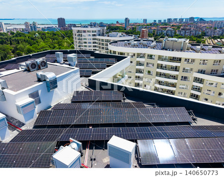 Solar panels installed on rooftops of buildings in a city with a coastal view under clear blue skies in the afternoon Solar panels installed on rooftops of buildings in a city with a coastal view under clear blue skies in the afternoon 140650773