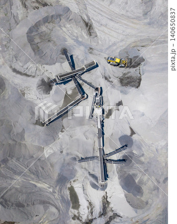 Granite quarrying site with machinery and stone extraction activities taking place in an operational area during daytime hours Granite quarrying site with machinery and stone extraction activities taking place in an operational area during daytime hours 140650837