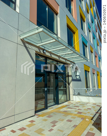 Modern building entrance with colorful panels and clear sky in the background at midday 140650971