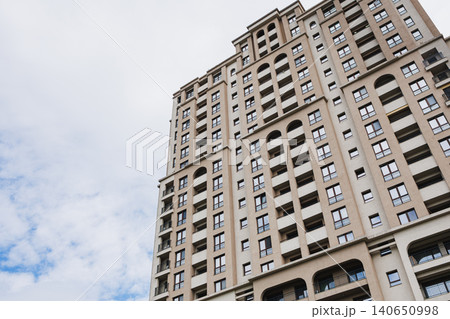 Soaring residential tower reaching toward sky with layered balconies and arched openings, evoking ambition, height and metropolitan energy for lifestyle and development use 140650998