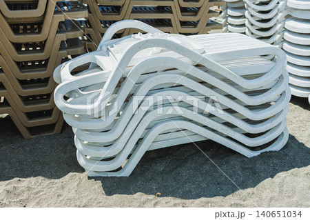 Contoured lounger creates flowing wave design on sunlight gravel. Elegant curved sunbed forms wavelike structure over illuminated gravel surface with modern minimalist style Contoured lounger creates flowing wave design on sunlight gravel. Elegant curved sunbed forms wavelike structure over illuminated gravel surface with modern minimalist style 140651034